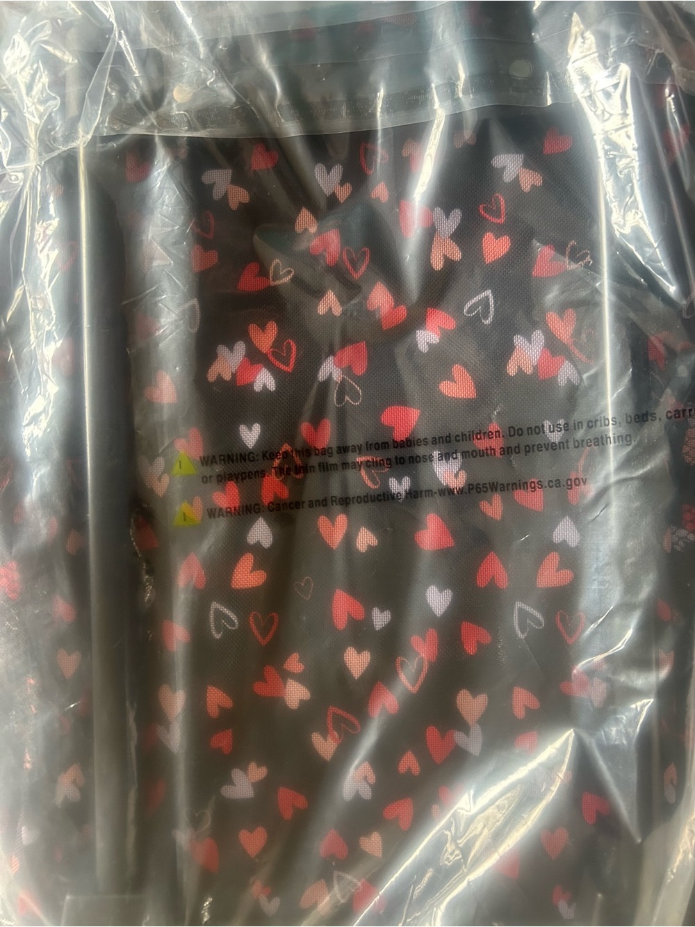 Woman Within Black Travel Bag with Pink and Red Heart Print